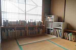 ein Zimmer mit Regalen voller Bücher und einem Fenster in der Unterkunft rento in Sobetsu