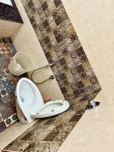 a toilet in a bathroom with a tiled wall at Suites by the Glaswater in Kalyānpur