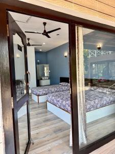 a room with two beds and a mirror at Suites by the Glaswater in Kalyānpur +22 photos