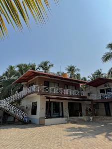 a building with a balcony and palm trees at Suites by the Glaswater in Kalyānpur