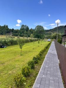 a walkway in a field with trees in it at Apartamenty Lisovychok in Richka