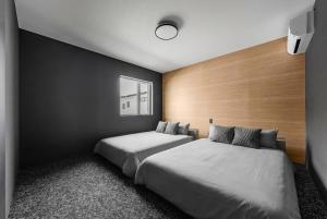 a bedroom with two beds and a wooden wall at U suzukou in Asahikawa +62 photos