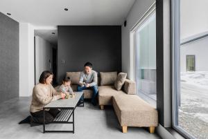 a family sitting in a living room with a table at U suzukou in Asahikawa