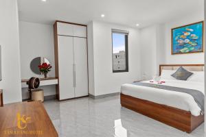 a bedroom with a bed and a table and a window at Tâm Khang Hotel in Móng Cái