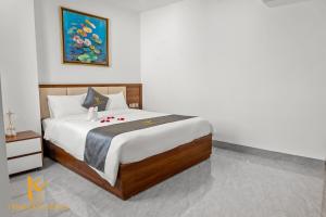 a bedroom with a large bed with white sheets at Tâm Khang Hotel in Móng Cái