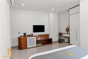 a white room with a television and a bed at Tâm Khang Hotel in Móng Cái