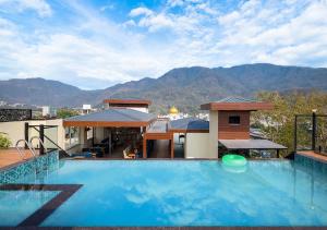 a large swimming pool with a view of the mountains at Saltstayz Autograph - Rishikesh Near Triveni Ghat in Rishīkesh