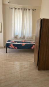 a bed in a room with a window at Peaceful & hygienic stay , Ideal for working professionals, Great for solo female travelers in Pune