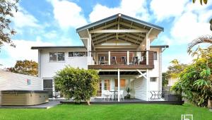 a large white house with a large deck at Natuna Lakeside Retreat in Budgewoi