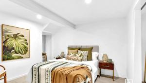 a bedroom with a bed with white walls at Natuna Lakeside Retreat in Budgewoi