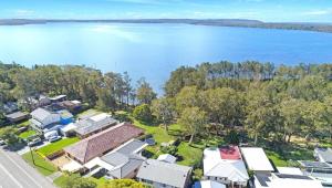 an aerial view of houses and the water at Natuna Lakeside Retreat in Budgewoi +10 photos
