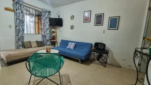 a living room with a blue bed and a couch at La Casita Puerto Arista in Puerto Arista