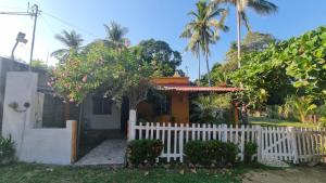 a house with a white fence in front of it at La Casita Puerto Arista in Puerto Arista