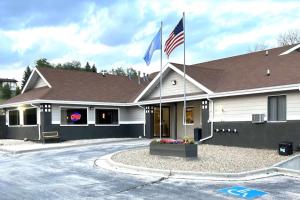 a house with two flags in front of it at Super 8 by Wyndham Hot Springs in Hot Springs