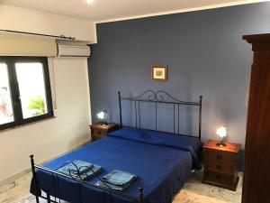 a bedroom with a bed with blue sheets and a table at Terrazze sul Mare Melito Di Porto Salvo in Melito di Porto Salvo