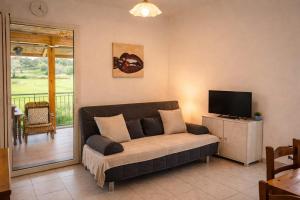 a living room with a couch and a flat screen tv at Noi - Casa vacanza in Attimis