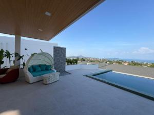 a patio with a blue couch and a swimming pool at Luxurious Villa with Private Indoor Pool in Bophut