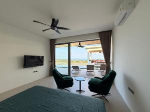 a bedroom with a bed and chairs and a television at Luxurious Villa with Private Indoor Pool in Bophut