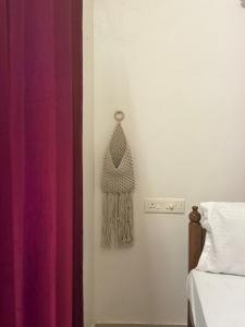 a bedroom with a bed and a purple curtain at Villa mud apples varkala in Varkala