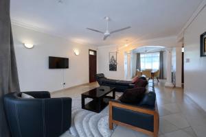 a living room with two couches and a tv at Ary Homestay Nyali At Shikara Apartments 5th Avenue Nyali, Mombasa, Kenya in Mombasa