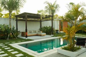 a house with a swimming pool and a pavilion at The Placo Villa Uluwatu in Denpasar