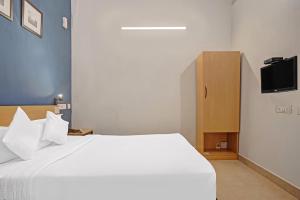 a bedroom with a large white bed and a tv at Open Hotel by Olive - Sadha Siva Airport Road, Chennai in Chennai