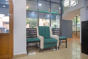 two chairs in a room with windows at Open Hotel by Olive - Sadha Siva Airport Road, Chennai in Chennai