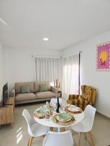 a living room with a table and chairs and a couch at Apartamento playa de Miramar in Miramar