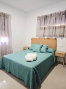 a bedroom with a bed with two towels on it at Apartamento playa de Miramar in Miramar