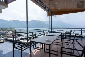 a balcony with tables and chairs and a view of the water at Hotel Kaavi in Pokhara