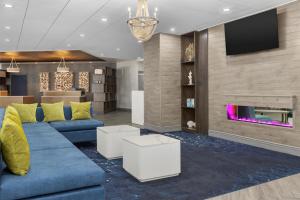 a living room with a blue couch and a tv at DoubleTree by Hilton Salisbury in Salisbury