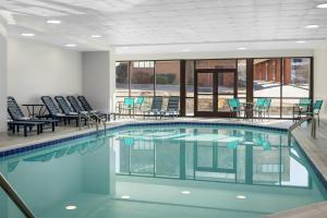a large swimming pool with chairs and tables in a building at DoubleTree by Hilton Salisbury in Salisbury