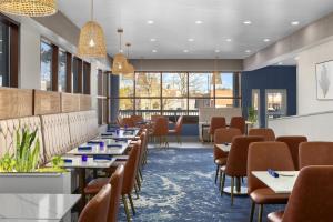 a dining room with tables and chairs and windows at DoubleTree by Hilton Salisbury in Salisbury
