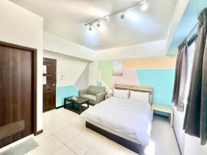 a bedroom with a bed and a chair in it at 卡布里 in Taichung