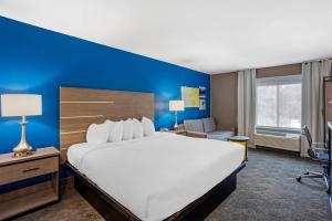 a hotel room with a large bed and a blue wall at Comfort Inn & Suites Harrisburg-Hershey North in Manor Acres +59 photos