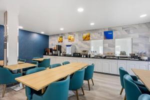 a restaurant with wooden tables and blue chairs at Comfort Inn & Suites Harrisburg-Hershey North in Manor Acres