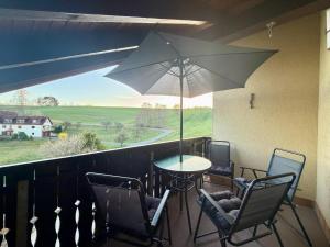 a patio with a table and chairs and an umbrella at Rauschelbach Loft 9 in Poppenhausen