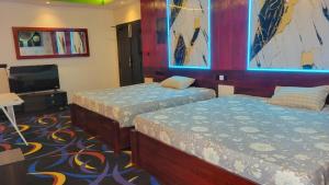 a room with two beds and a television at Sas Tower Hotel in Trincomalee +13 photos