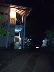 a car parked in front of a house at night at Tissa Resort in Tissamaharama