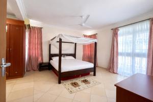 a bedroom with a bed with a canopy at Ary Homestay Nyali At Shikara Apartments 5th Avenue Nyali, Mombasa, Kenya in Mombasa +10 photos