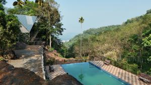 a swimming pool in the middle of a mountain at Lostcabins in Vallikavungal