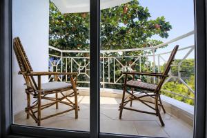 two chairs sitting on a balcony with a view at Ary Homestay Nyali At Shikara Apartments 5th Avenue Nyali, Mombasa, Kenya in Mombasa