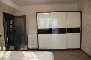 a bedroom with a large white and black closet at Apartment on Komsomolskaya 295 in Yuzhno-Sakhalinsk