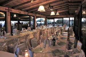 a long dining room with white tables and chairs at Le Due Lune in Cesano