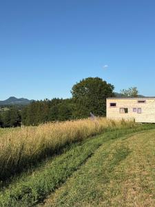 a building in the middle of a field at La Tiny de Papa un logement Eco-responsable in Saint-Pierre-le-Chastel