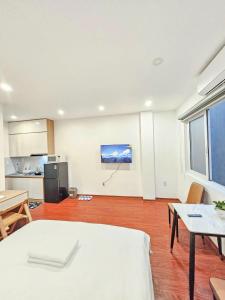a living room with a table and a tv on the wall at Lakenest 06 - Quiet Place in Hanoi