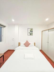 a white bedroom with a large white bed at Lakenest 06 - Quiet Place in Hanoi