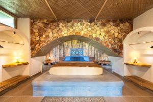 a bedroom with a bed in a stone wall at Highlife Hill Villa in General Luna