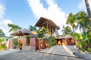 a resort with palm trees in front of it at Highlife Hill Villa in General Luna