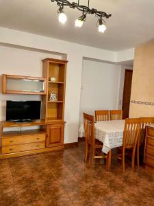 a dining room with a table and a tv at Hotel Rural Casa Ramiro in Cedrillas